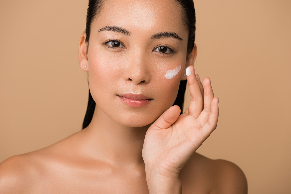 woman applying cream to her face