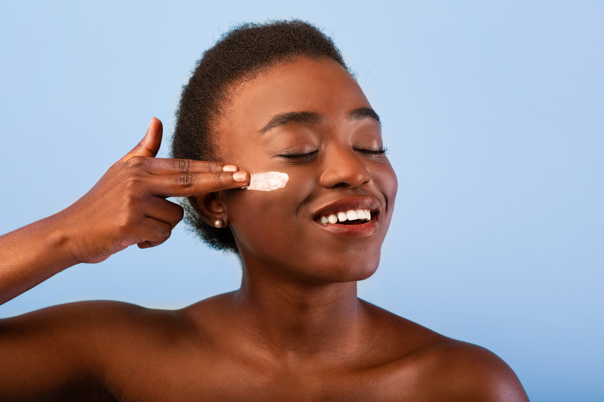 woman applying moisturizer to her cheek