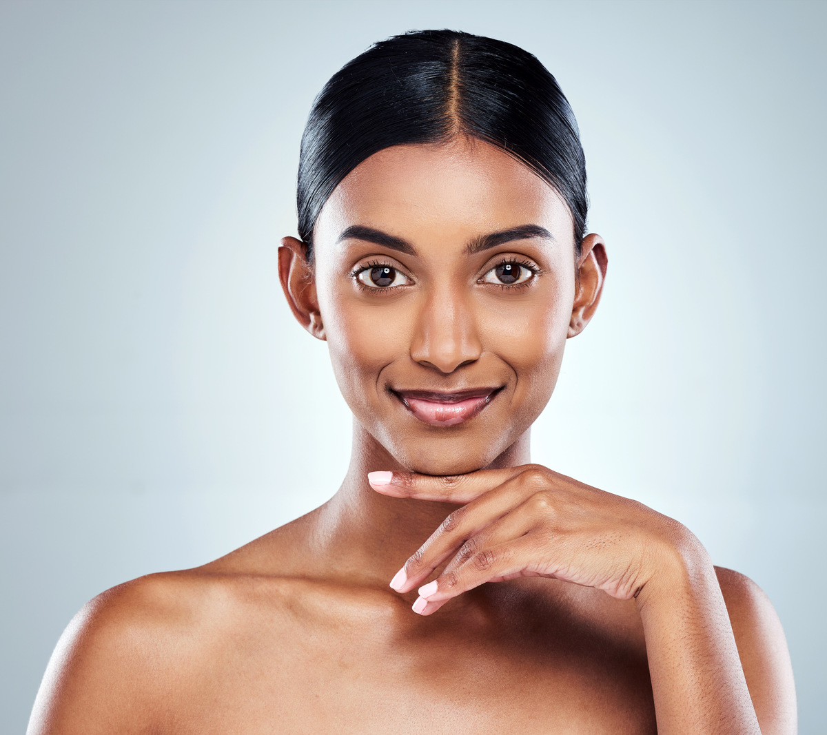 woman posing with hand under chin, smiling